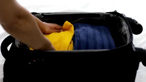 A man puts things in a suitcase. Preparation for a trip or journey. packing Vídeos de archivo 336236444