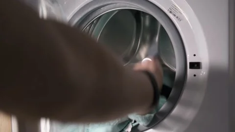 A man puts things in the washing machine, close-up Stock Footage 232789941