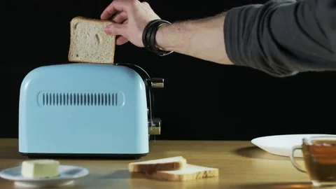 Man Puts Two Loaves of Bread Into an Electric Toaster Stock Footage 69175869
