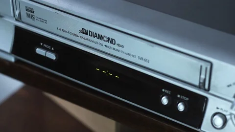 A man puts a VHS cassette in the old player. Stock Footage 125513883