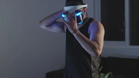 Man Puts Virtual Reality Goggles on, Ready to Play Video Game, Raises Gun Stock Footage 108880535