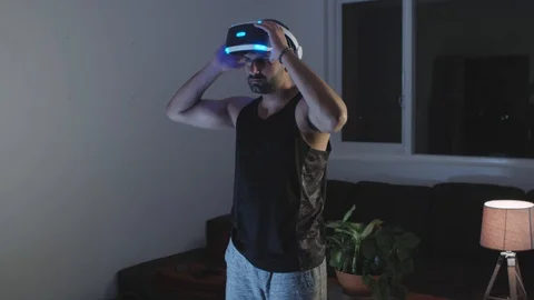 Man Puts Virtual Reality Goggles on, Ready to Play Video Game, Pushes Button Stock Footage 108881942