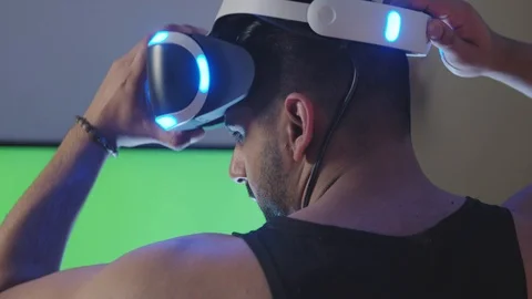 Man Puts Virtual Reality Googles on Head and Raises Gun for Battle, Green Screen Stock Footage 108880993