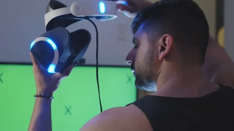 Man Puts Virtual Reality Googles on Head and Raises Gun for Battle, Green Screen Stock Footage 108881097