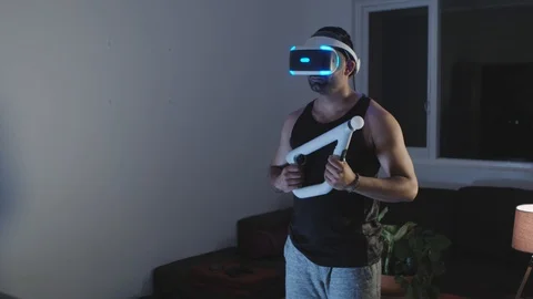 Man Puts Virtual Reality Googles on Head and Raises Gun, Ready for Battle Stock Footage 108882052