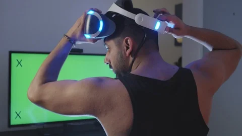 Man Puts Virtual Reality Googles on Head and Raises Gun for Battle, Green Screen Stock Footage 108882251