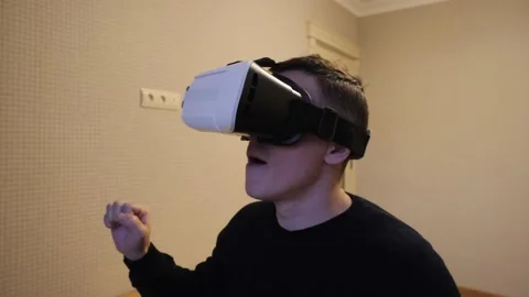 The man puts on VR glasses and is amazed. Video stock 143898424