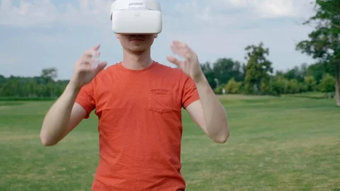 A man puts a VR headset on his head in a park Stock Footage 112803717