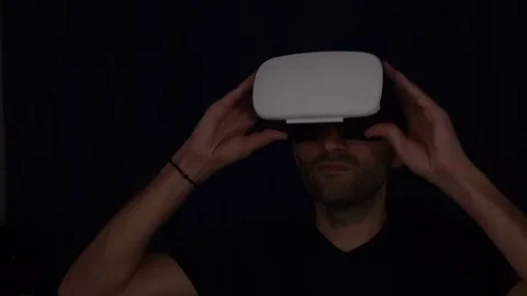 Man puts on a VR Headset. Man wearing virtual reality goggles. Man Wearing VR Stock Footage 73987105