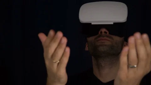 Man puts on a VR Headset. Man wearing virtual reality goggles. Man Wearing VR Stock Footage 73987260