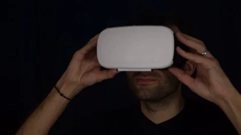Man puts on a VR Headset. Man wearing virtual reality goggles. Man Wearing VR Stock Footage 73987325