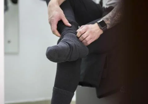 A man puts on warm winter socks 库存照片