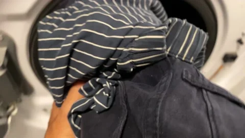 Man puts washing machine subjective point of view of clothes i washing machine Stock Footage 228294449