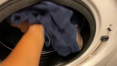 Man puts washing machine subjective point of view of clothes i washing machine Stock Footage 228294504