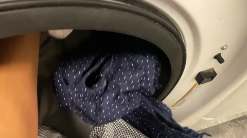 Man puts washing machine subjective point of view of clothes i washing machine Stock Footage 228294512