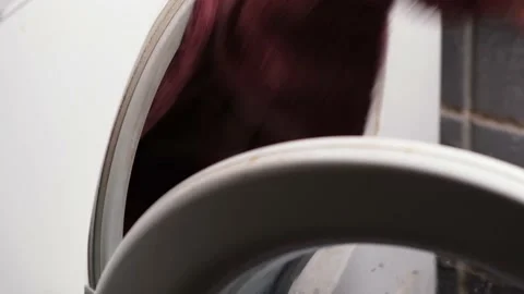 A man puts washing things in the washing machine. Stock Footage 165066109