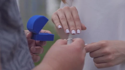 A man puts a wedding ring on a woman's hand Stock Footage 108645888