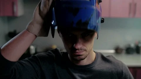 Man puts on a welder's mask before starting welding Stock Footage 151646800
