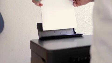A man puts white paper into the printer, Laser printer in operation. Close-up of Stock Footage 270793775