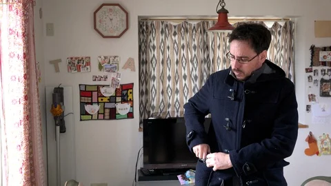 Man puts on a wool cap at home during the day to go out. Camera fix, angle Video stock 107003336