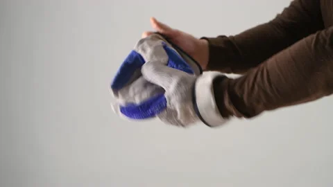 The man puts on work gloves before work and checks their quality Stock Footage 152967313