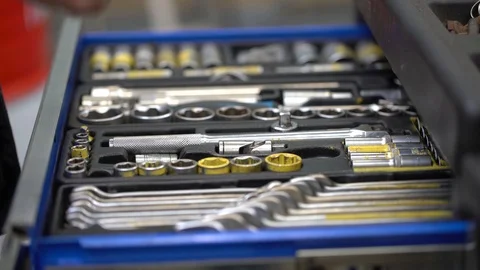 A man puts a wrench in a box with tools and bolts Stock Footage 122244720