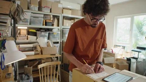 Man Putting Address Labels on Parcels in Delivery Service Office 動画素材 238695582