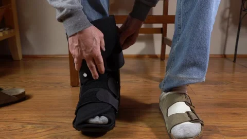 A man putting an air cast on his injured ankle Stock Footage 297319043
