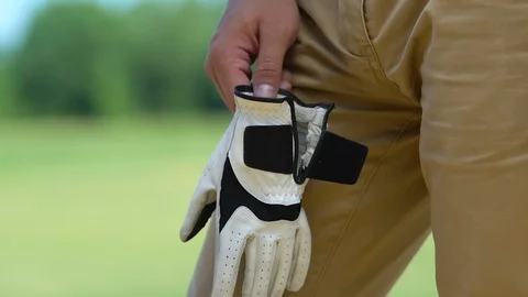 Man putting on and fixing on hand professional leather glove, golf game, hobby Stock Footage 114346740