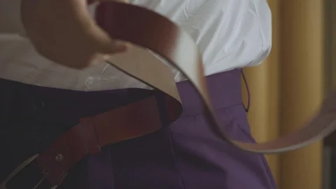 Man putting on a belt Stock Footage 114508650