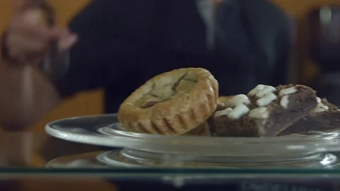 Man putting a biscuit into a tray using tongs Vídeos de archivo 75166826