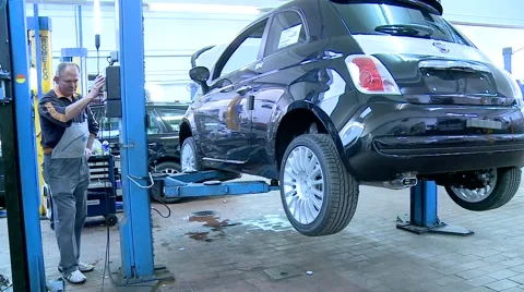 Man putting a car down with a machine Stock Footage 45658054