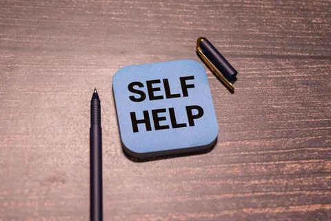Man putting a card with text self help in the pocket. Stock Photos