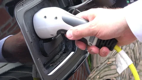 Man putting in the charge plug of an electric vehicle 4k Stock Footage 108615371