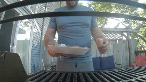 Man putting chicken on the grill Stock Footage 110874312