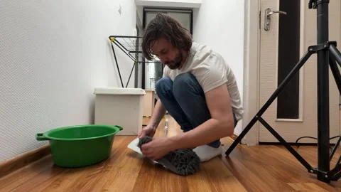 Man putting cleaning cloth on mop at home, preparation for housework showing Stock Footage 336981760