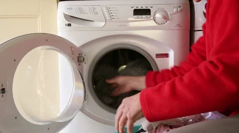 Man putting clothes into washing machine Stock Footage 22437608