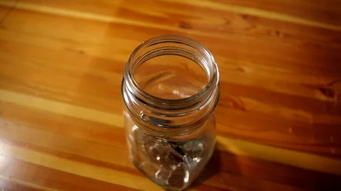 A man putting coins into a jar. Stock Footage 106918359