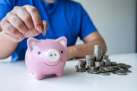 Man putting coins to planning growing saving to strategy with piggy bank for Stock Photos