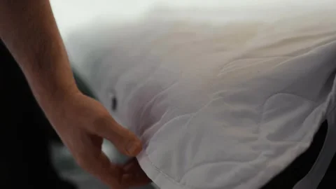 Man putting cotton bedding into under the couch storage place. Stock Footage 319334711