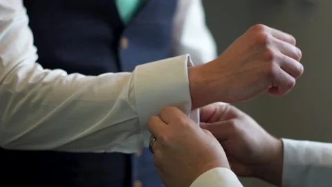 Man putting on cufflinks for another man. Stock Footage 278047514