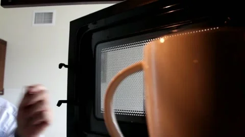 Man putting cup of coffee in microwave and pulling out  after warming Video stock 44986260