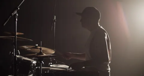 Man putting on earphone and playing beat on drums Stock Footage 249853524