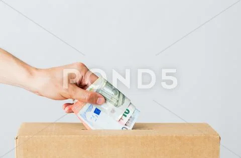 Man putting euro money into donation box Stock Photos