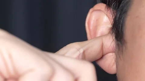 Man putting a finger into her ear / Itchy ear isolated with copy space Stock Footage 163296572