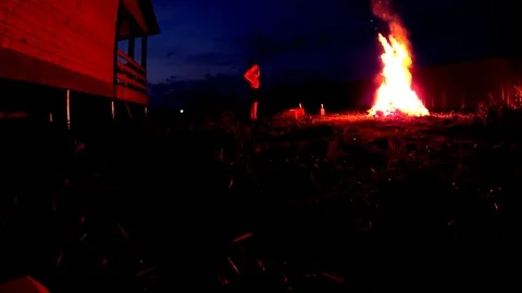Man putting firewoods to a large bonfire, closeup shot Stock Footage 75247247