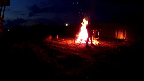 Man putting firewoods to a large bonfire, closeup shot Video stock 75247324