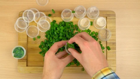 Man putting fresh chive leaves intro plastic containers to freeze. Video stock 108429962