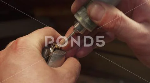 Man putting gemstone into the jewelry item Stock Photos