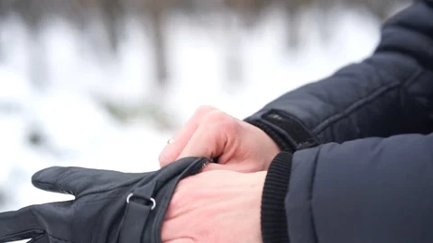 Man putting on gloves in cold white winter Vídeo Stock 98736984
